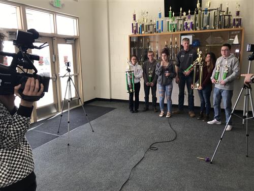 A student operates a wireless camera system during a remote video shoot. 