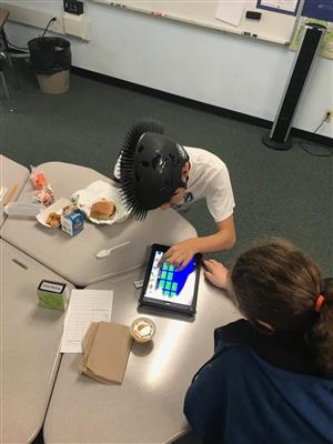 Peer and student using iPad app to talk about lunch 