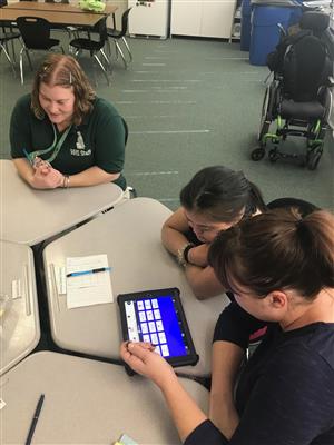 Two teachers and student communicating with iPad with communication app 