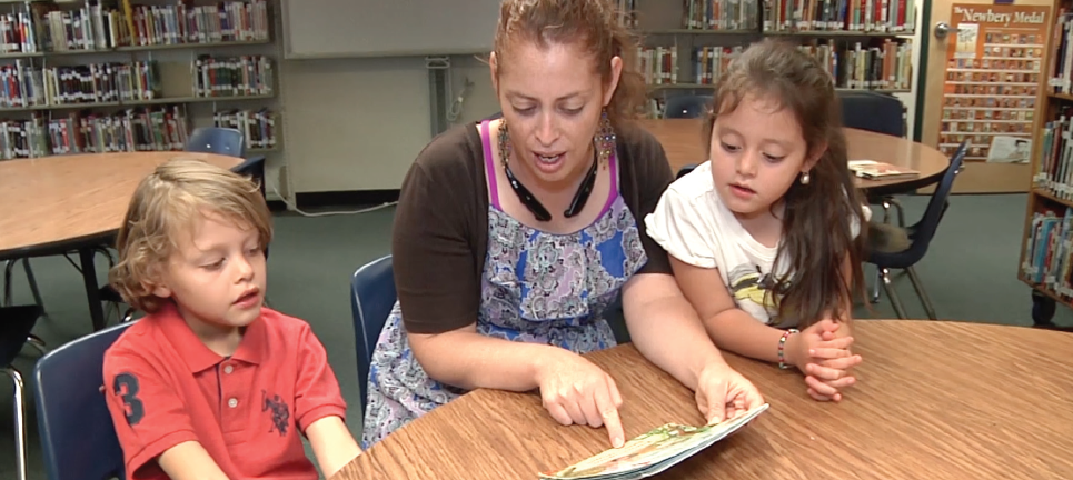 teacher reading with two students 
